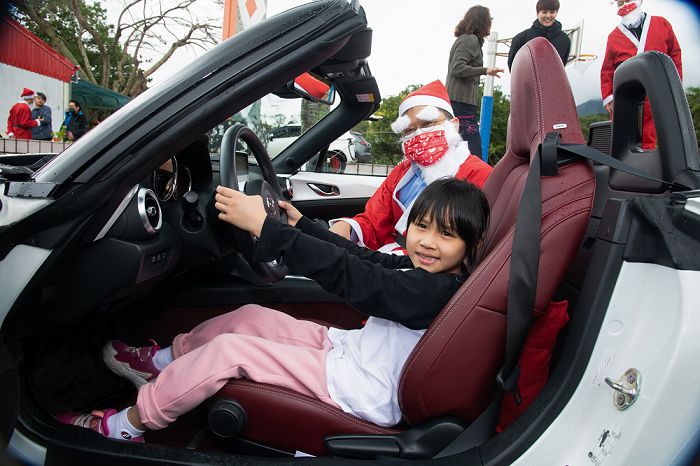 靜浦國小學生興奮地與MAZDA MX-5合影留念，全校師生體驗乘風的喜悅。