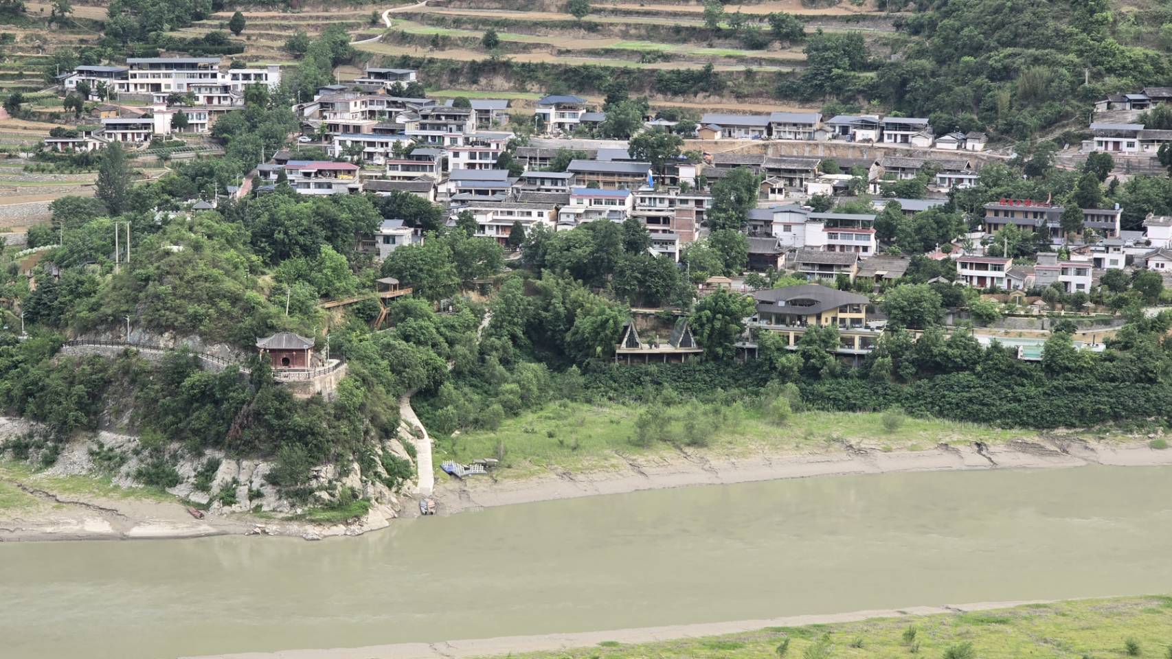 由對岸遠望諸葛廬民宿，建築隐在山間水畔。（圖／虞煥榮攝）