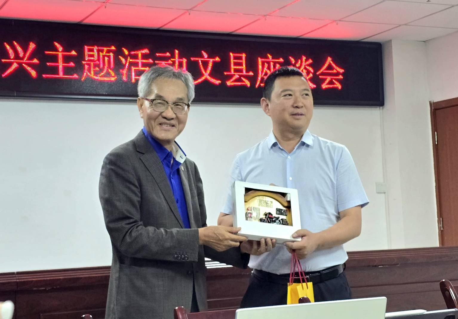 王海飛與黃丙喜互贈禮物交流，期許參訪行程順利成功。